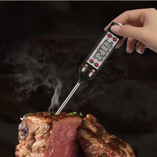 Digital meat thermometer measuring steak temperature